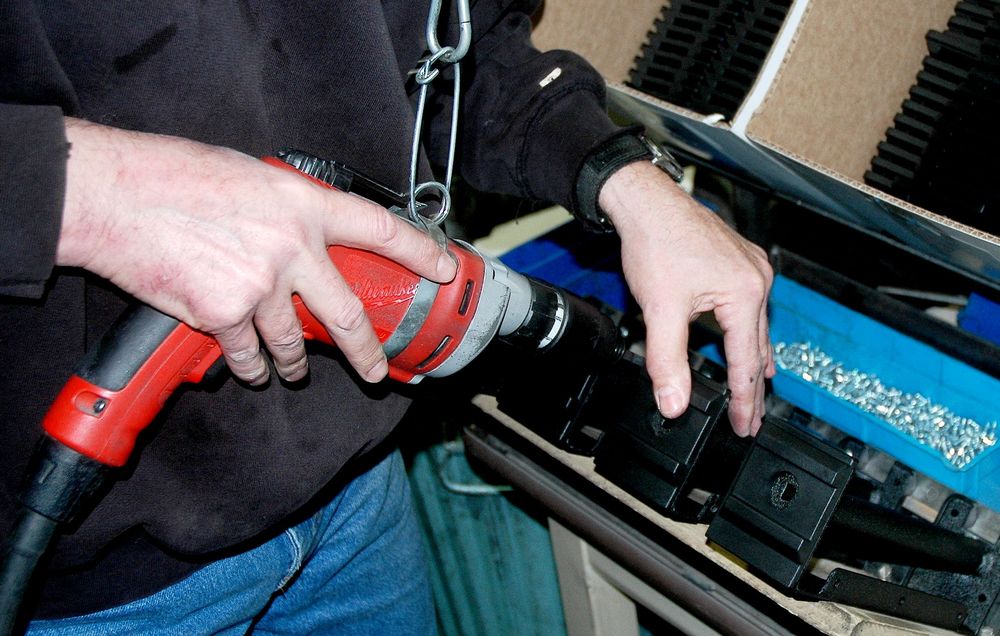 Machinist drills hole during the final assembly process 